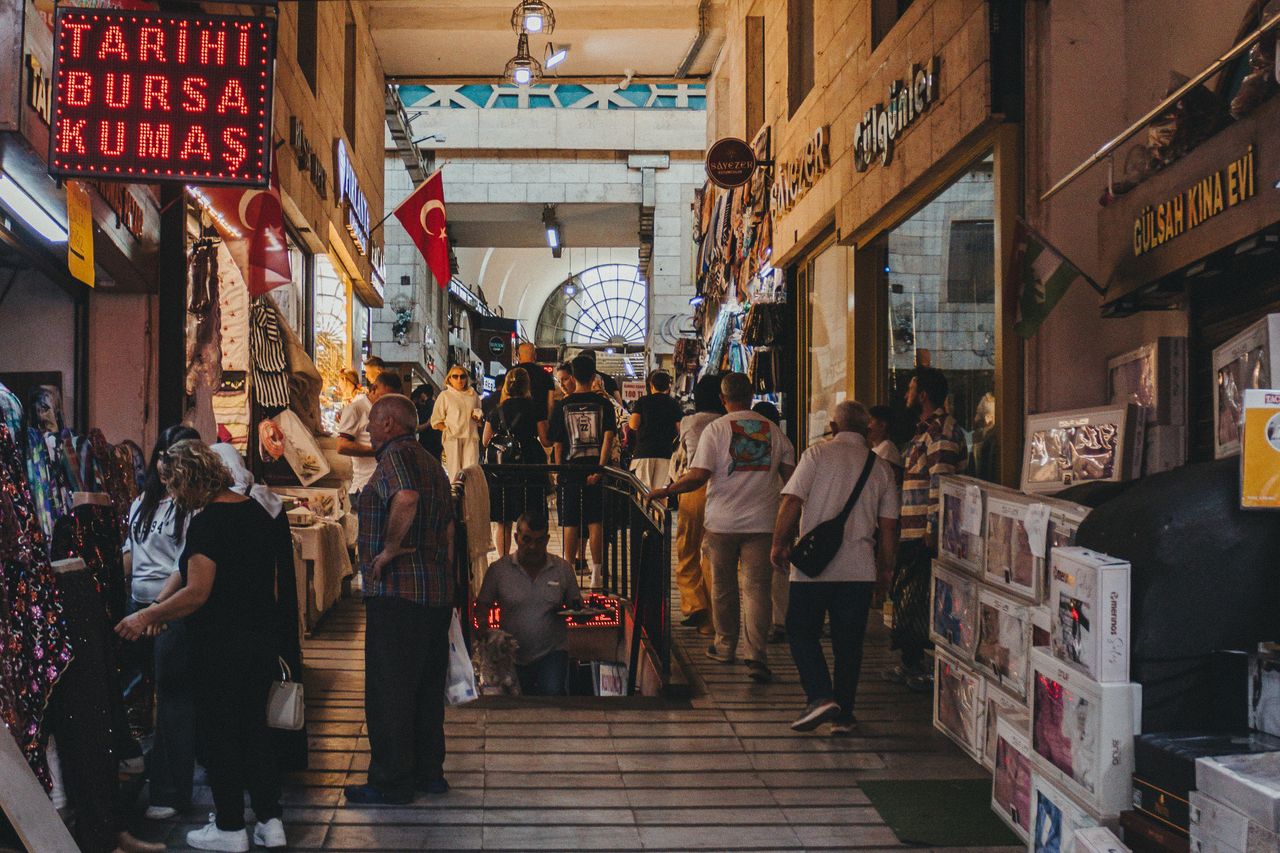 Vibrant indoor scene of a busy Turkish bazaar with locals and tourists shopping.